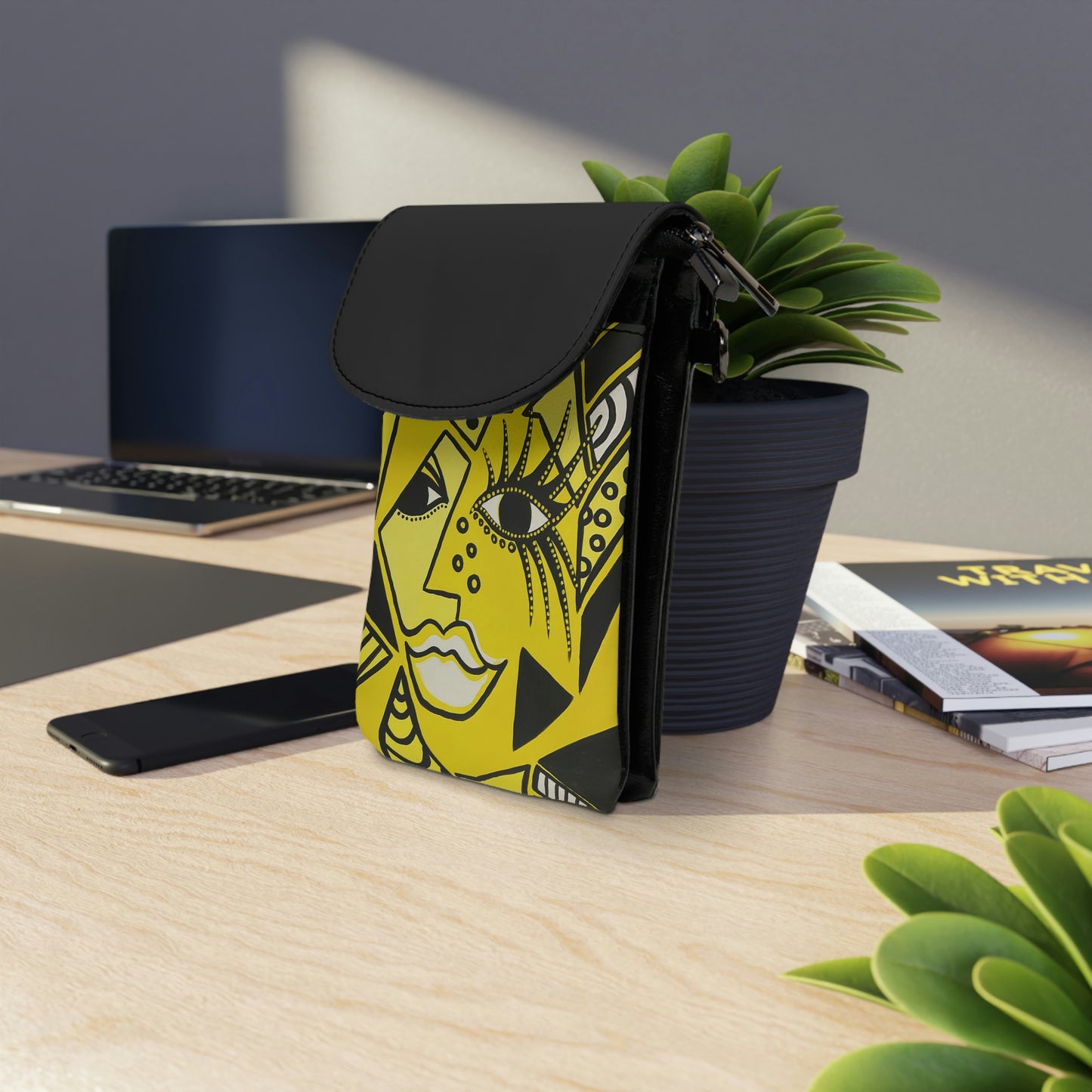 Handytasche lehnt sich mit der Rückseite an einem Blumentopf